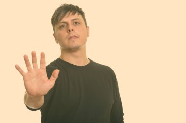 Beyaz arka planda uzun kollu gömlek giyen bir adamın stüdyo fotoğrafı.