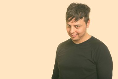 Beyaz arka planda uzun kollu gömlek giyen bir adamın stüdyo fotoğrafı.