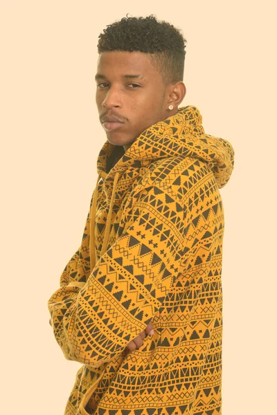 Studio shot of young handsome African man with afro hair wearing hoodie isolated against white background