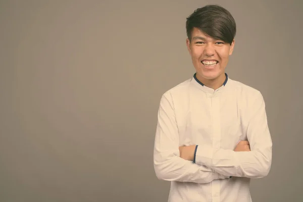 Ung asiatisk tonåring pojke mot grå bakgrund — Stockfoto