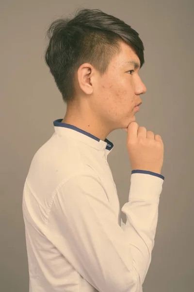 Genç Asyalı çocuk gri arka plana karşı — Stok fotoğraf