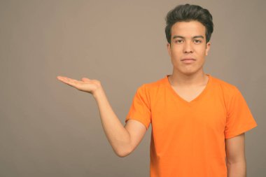 Gri arka planda Asyalı genç bir adamın portresi