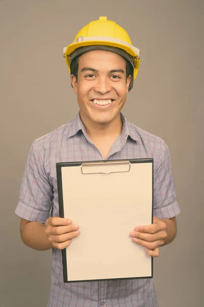 Ung asiatisk affärsman bär hatt mot grå bakgrund — Stockfoto