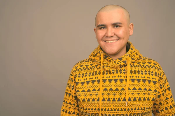 Joven calvo asiático hombre contra gris fondo —  Fotos de Stock