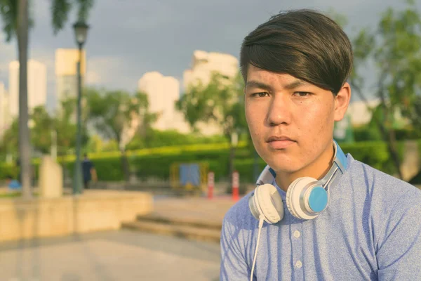 Юнак - підліток у навушниках під час відпочинку в парку. — стокове фото