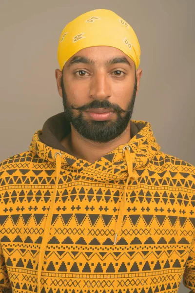 Joven hombre indio guapo contra fondo gris —  Fotos de Stock