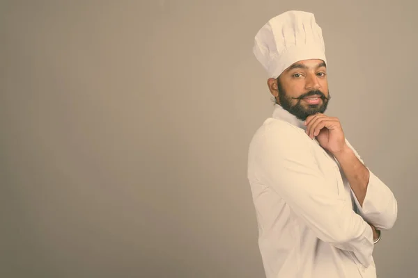 Joven guapo indio hombre chef contra gris fondo —  Fotos de Stock