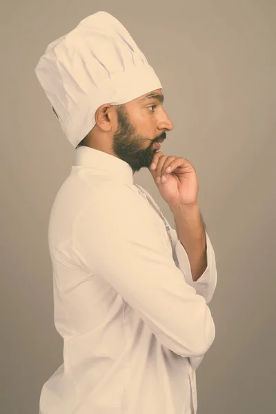 Молодий індійський кухар на сірому фоні. — стокове фото