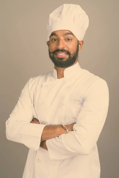 Jovem bonito índio homem chef contra cinza fundo — Fotografia de Stock