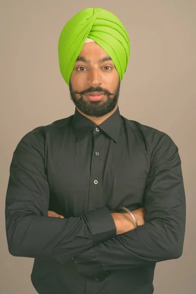 Ung stilig indisk sikh affärsman bär turban mot grå bakgrund — Stockfoto