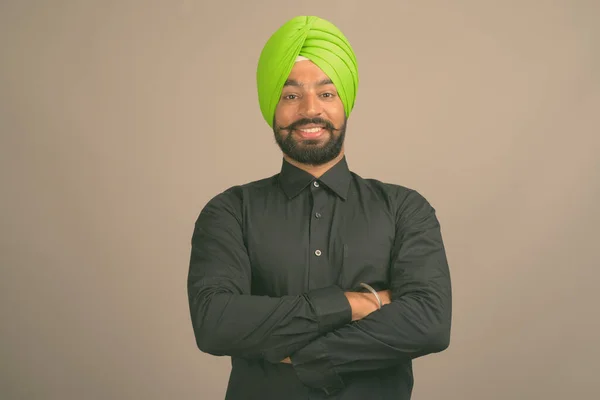 Joven hombre de negocios sikh indio guapo usando turbante contra fondo gris —  Fotos de Stock