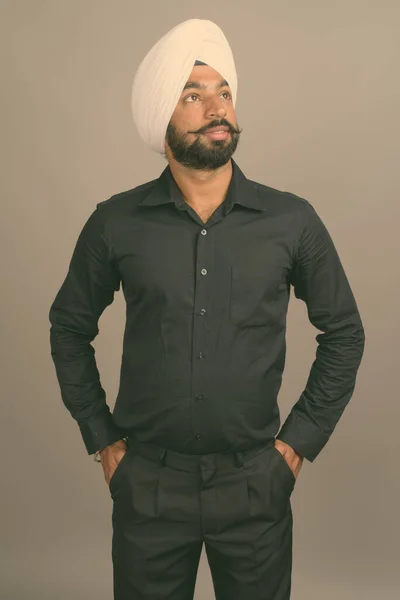 Jovem bonito indiano Sikh empresário vestindo turbante contra fundo cinza — Fotografia de Stock