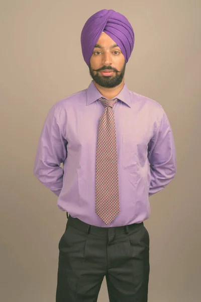 若いですハンサムなインドのシックビジネスマンは灰色の背景にターバンを身に着けて — ストック写真