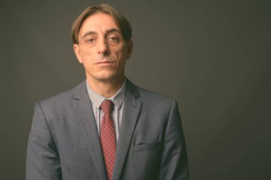 Olgun yakışıklı İtalyan işadamı gri arka planda