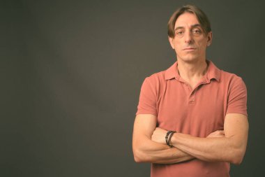Gri arka planda olgun, yakışıklı bir İtalyan.