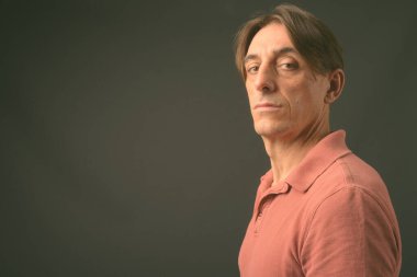 Gri arka planda olgun, yakışıklı bir İtalyan.