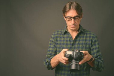 Gri arka planda olgun, yakışıklı bir İtalyan.