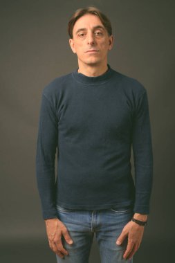 Gri arka planda olgun, yakışıklı bir İtalyan.
