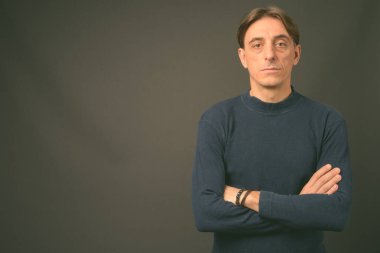 Gri arka planda olgun, yakışıklı bir İtalyan.