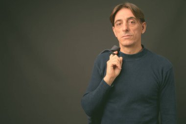 Gri arka planda olgun, yakışıklı bir İtalyan.