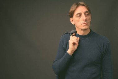 Gri arka planda olgun, yakışıklı bir İtalyan.