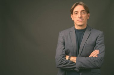 Olgun yakışıklı İtalyan işadamı gri arka planda
