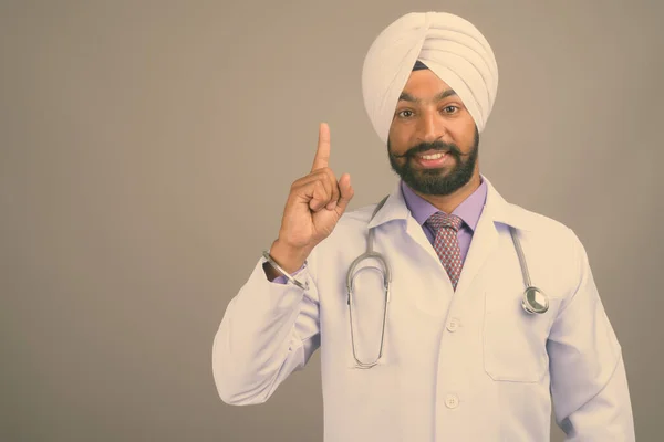 Jovem bonito indiano Sikh homem médico contra fundo cinza — Fotografia de Stock