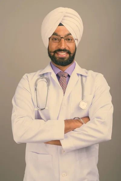 Jovem bonito indiano Sikh homem médico contra fundo cinza — Fotografia de Stock