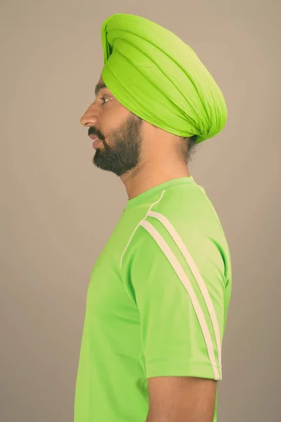 Young handsome Indian Sikh man wearing turban against gray background — Stock Photo, Image