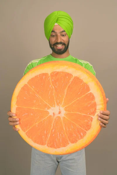 Young handsome Indian Sikh man wearing turban against gray background — Stock Photo, Image