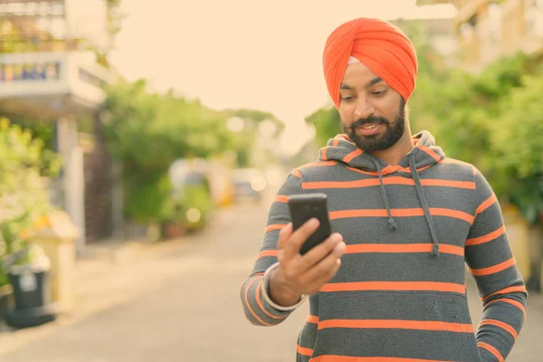 Young handsome Indian Sikh man wearing turban in the streets outdoors — Stock Photo, Image