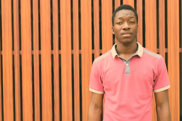 Joven hombre africano negro contra puerta de madera al aire libre — Foto de Stock