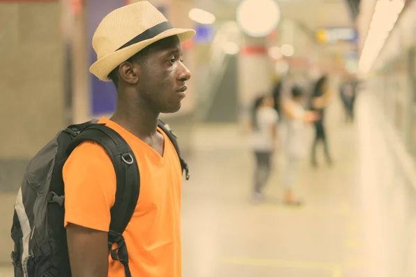 Vue du profil d'un jeune touriste noir africain en attente d'un train dans le métro de Bangkok Thaïlande — Photo