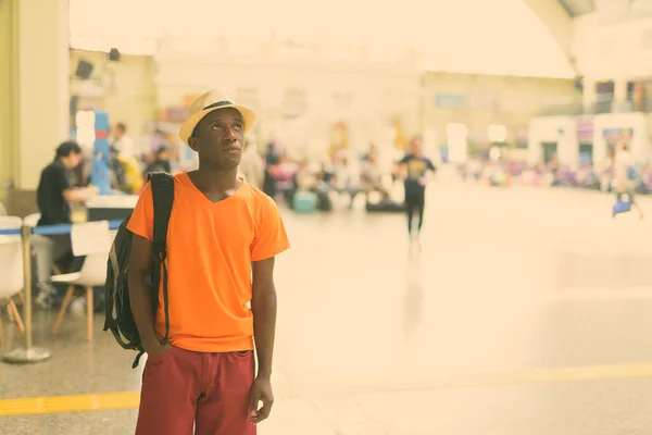 Νεαρός μαύρος Αφρικανός τουρίστας σκέφτεται μέσα στο σιδηροδρομικό σταθμό στην Μπανγκόκ της Ταϊλάνδης — Φωτογραφία Αρχείου