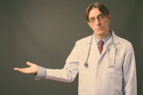 Reif hübsch italienisch mann doktor vor grauem hintergrund — Stockfoto