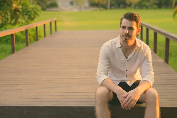 Portret van een jonge knappe man ontspannen in het park — Stockfoto