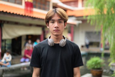 Yaz boyunca geleneksel Asya Zen bahçesinde Taylandlı genç bir adam. Çeşitli kavramlar ve kullanımlar için kendine güvenen, rahat ve otantik görünüm