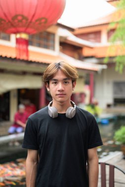 Yaz boyunca geleneksel Asya Zen bahçesinde Taylandlı genç bir adam. Çeşitli kavramlar ve kullanımlar için kendine güvenen, rahat ve otantik görünüm