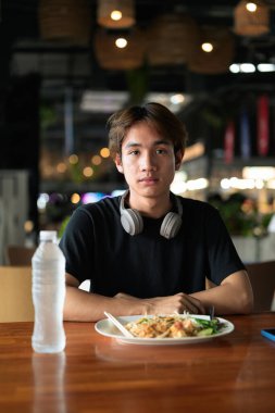 Tayland 'da Tayland erişteleri genç turistler tarafından yemek çubuklarıyla yenir. Asya 'da turistler ve yerliler tarafından sevilen ünlü sokak yemekleri..