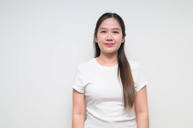 Sıradan beyaz tişört giyen Asyalı genç bir kadının stüdyo portresi.