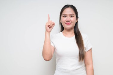 Sıradan beyaz tişört giyen Asyalı genç bir kadının stüdyo portresi.