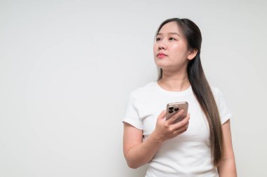 Sıradan beyaz tişört giyen Asyalı genç bir kadının stüdyo portresi.