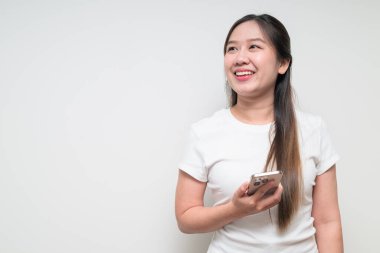 Sıradan beyaz tişört giyen Asyalı genç bir kadının stüdyo portresi.