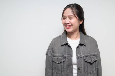 Beyaz arka planda gülümseyen Güneydoğu Asyalı genç bir kadının stüdyo portresi