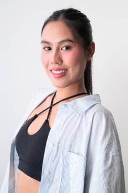 Beyaz arka planda genç, şirin Asyalı bir kadının stüdyo portresi