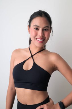 Beyaz arka planda genç, şirin Asyalı bir kadının stüdyo portresi