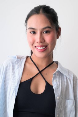 Beyaz arka planda genç, şirin Asyalı bir kadının stüdyo portresi