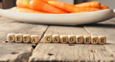 Ahşap dices kelime beta karoten ve arka kapağı transparan, sağlıklı beslenme kavramı içinde taze havuç