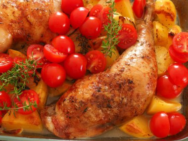 Lezzetli kızarmış tavuk budu taze otlar ve cam tavada domates ile