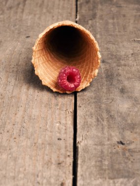 Bir dondurma koni rustik ahşap masa, diyet veya sağlıklı beslenme kavramı üzerinde bir organik ahududu